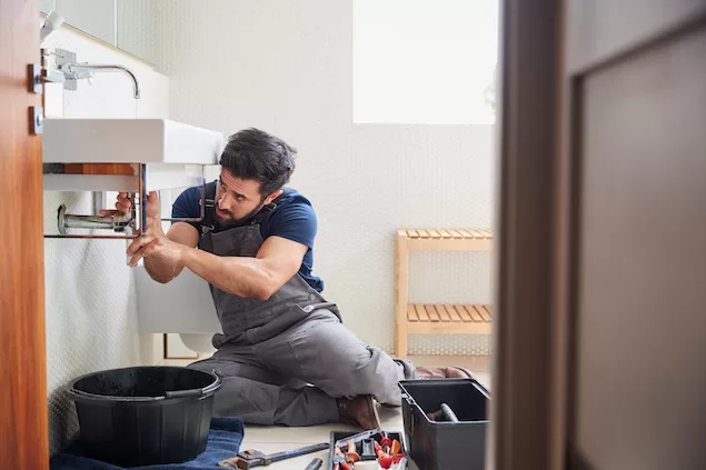 plumber working on sink